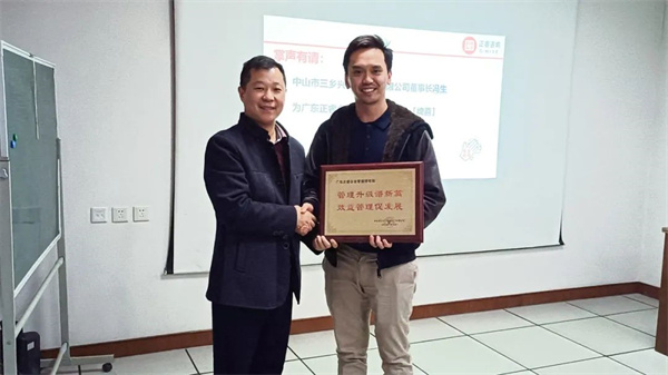兴隆总经理Kingsley先生（右）向蓝狮注册咨询集团颁发荣誉牌匾