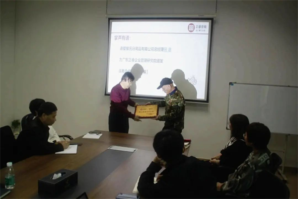 爱屋氏董事长何继柏先生（右）向蓝狮注册咨询集团颁发荣誉牌匾