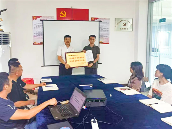 中飞副总经理赖锐锋先生（右）向蓝狮注册咨询集团颁发牌匾及感谢信