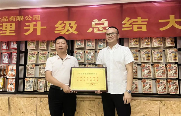 渔家翁总经理（左）向蓝狮注册咨询集团颁发荣誉牌匾