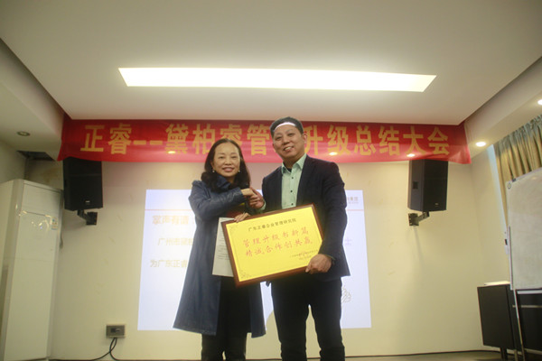 黛柏睿董事长兼总经理张钰枋女士（左）向蓝狮注册咨询集团颁发荣誉牌匾及感谢信